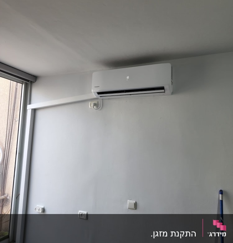 מזגן מותקן על קיר לבן בחדר